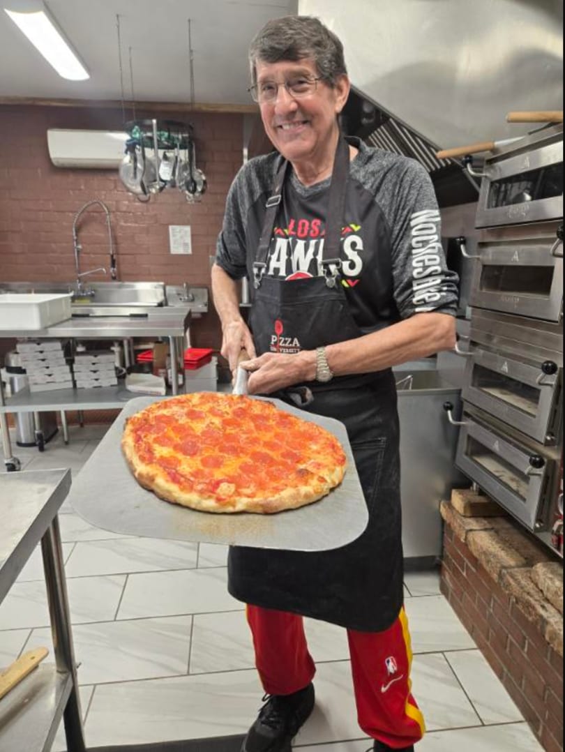 Jimmy pulling a fresh pepperoni pizza